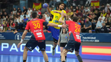 CORRECTION / Spain's pivot #30 Gedeon Guardiola Villaplana and Spain's left back #24 Viran Morros de Arguila try to block Brazil's left wing #83 Hugo Bryan Monte da Silva's shot on goal during the qualifying handball match for the 2024 Paris Olympic Games between Brazil and Spain at the Palau d'Esports in Granollers on March 17, 2024. (Photo by Pau Barrena / AFP) / "The erroneous mention[s] appearing in the metadata of this photo by Pau Barrena has been modified in AFP systems in the following manner: [between Brazil and Spain] instead of [between Slovenia and Bahrain]. Please immediately remove the erroneous mention[s] from all your online services and delete it (them) from your servers. If you have been authorized by AFP to distribute it (them) to third parties, please ensure that the same actions are carried out by them. Failure to promptly comply with these instructions will entail liability on your part for any continued or post notification usage. Therefore we thank you very much for all your attention and prompt action. We are sorry for the inconvenience this notification may cause and remain at your disposal for any further information you may require." (Photo by PAU BARRENA/AFP via Getty Images)