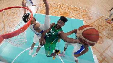 Cristiano Felicio, of Brazil, shoots around Victor Wembanyama, of France, in a men's basketball game at the 2024 Summer Olympics, Saturday, July 27, 2024, in Villeneuve-d'Ascq, France. (AP Photo/Mark J. Terrill,Pool)