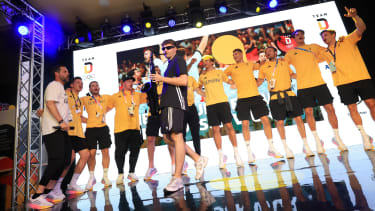 Ein Teil der deutschen Handball Mannschaft feiert mit dem Saxofonist André Schnura den Gewinn der Silbermedaille im Deutschen Haus aufgenommen am 11.08.2024 in Paris. Foto: Team D/picture-alliance/Karl-Josef Hildenbrand